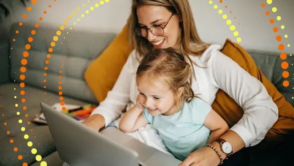 A woman and a child looking at a laptop and smiling